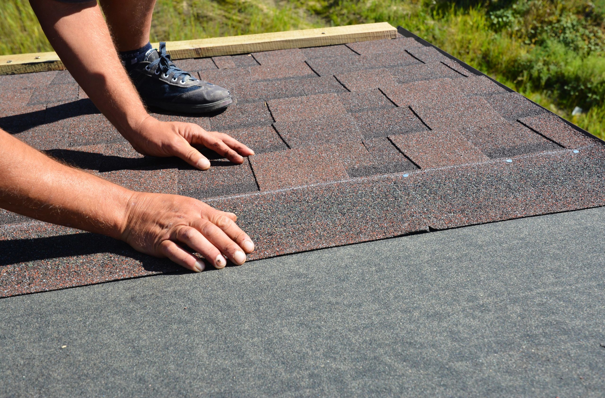 Roofer installing shingles close up