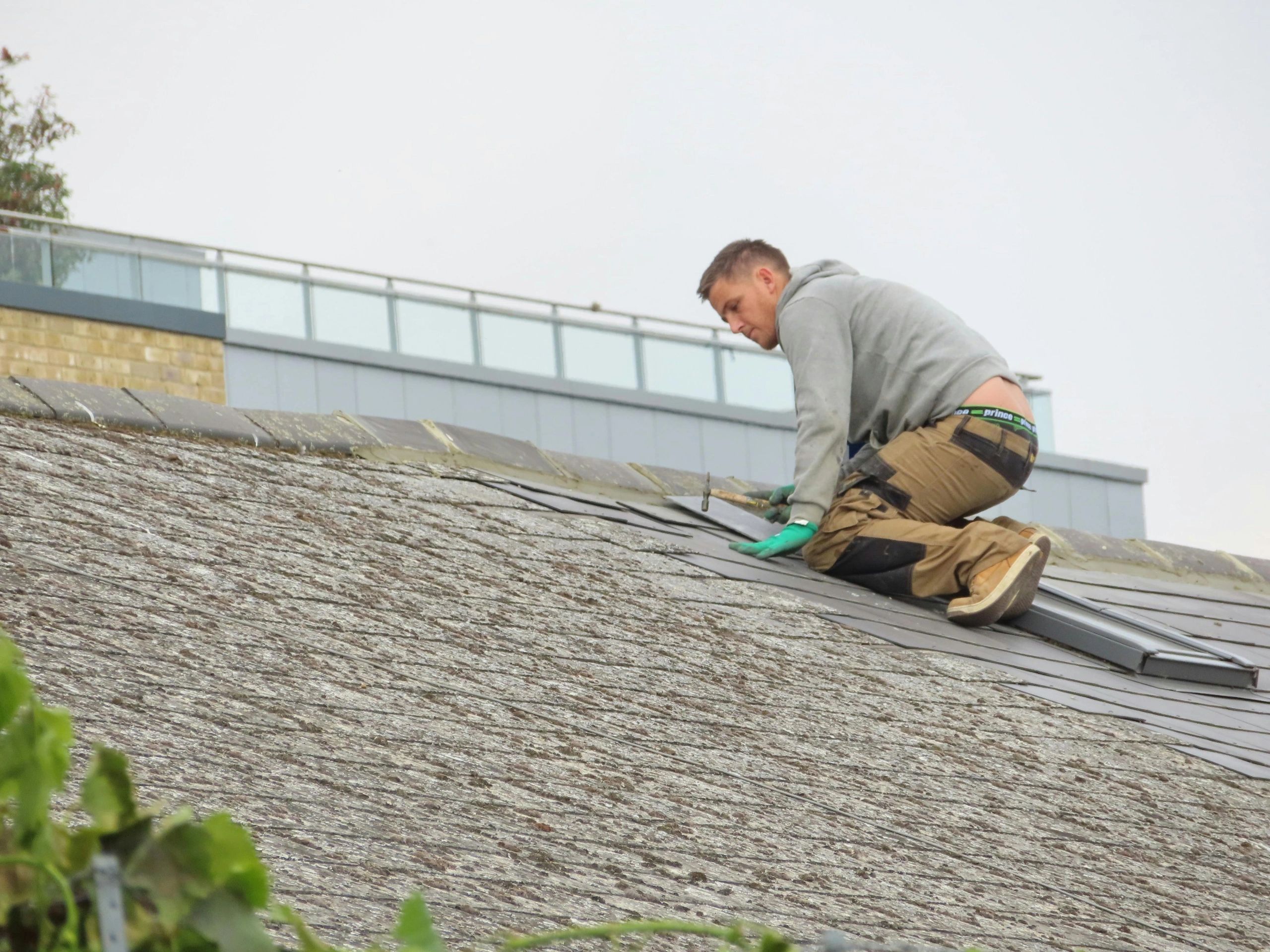 Roofer working on shingles installation